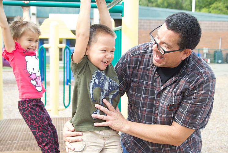 teacher-helping-kids-play-on-playground